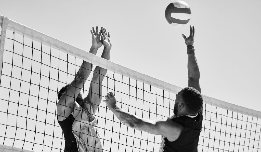 Beach, volleyball and team with competition at ocean and sea with exercise, sport and fitness. Summ.