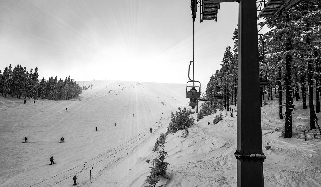 Cable cars hang on cables in a silent night ski resort against a stunning starry sky on a clear winter night. Winter and european vacation concept. Copyspace