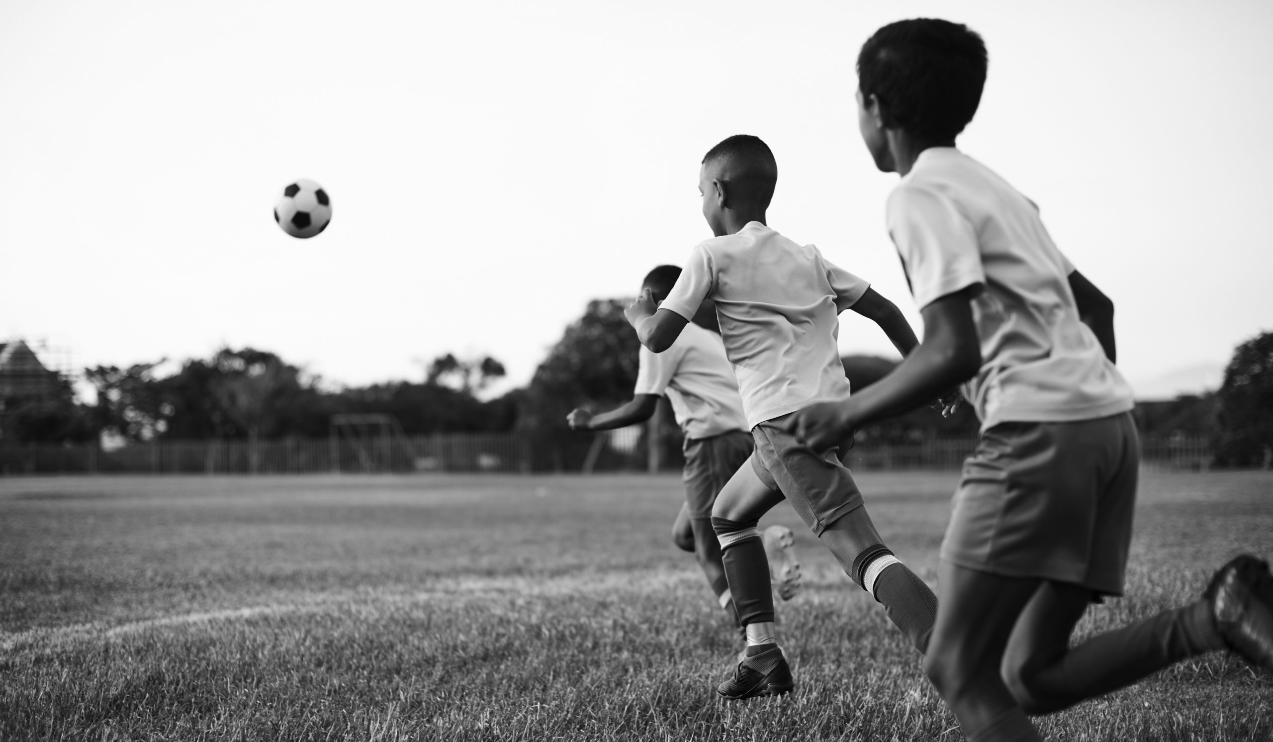 Shot of a group of young boys playing soccer on a sports field.