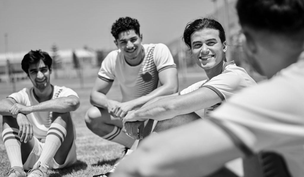 Soccer, team and meeting in sports conversation for game, planning or strategy on the field outdoor.