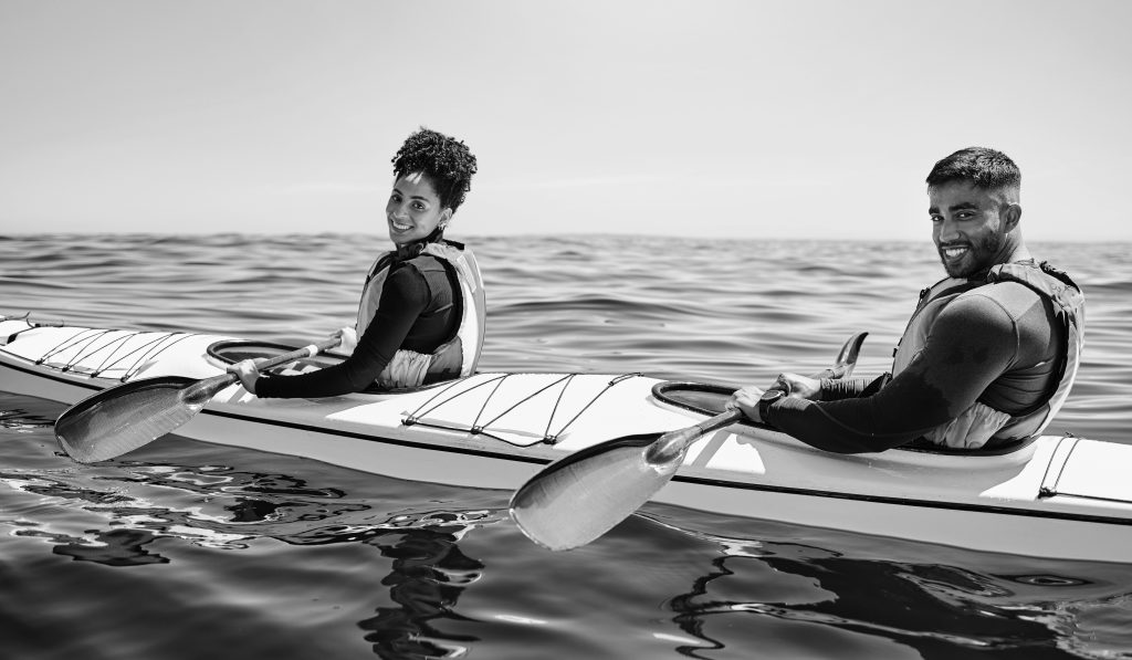 Sports, portrait of happy man and woman in kayak at lake, beach or river for exercise challenge. Oc.